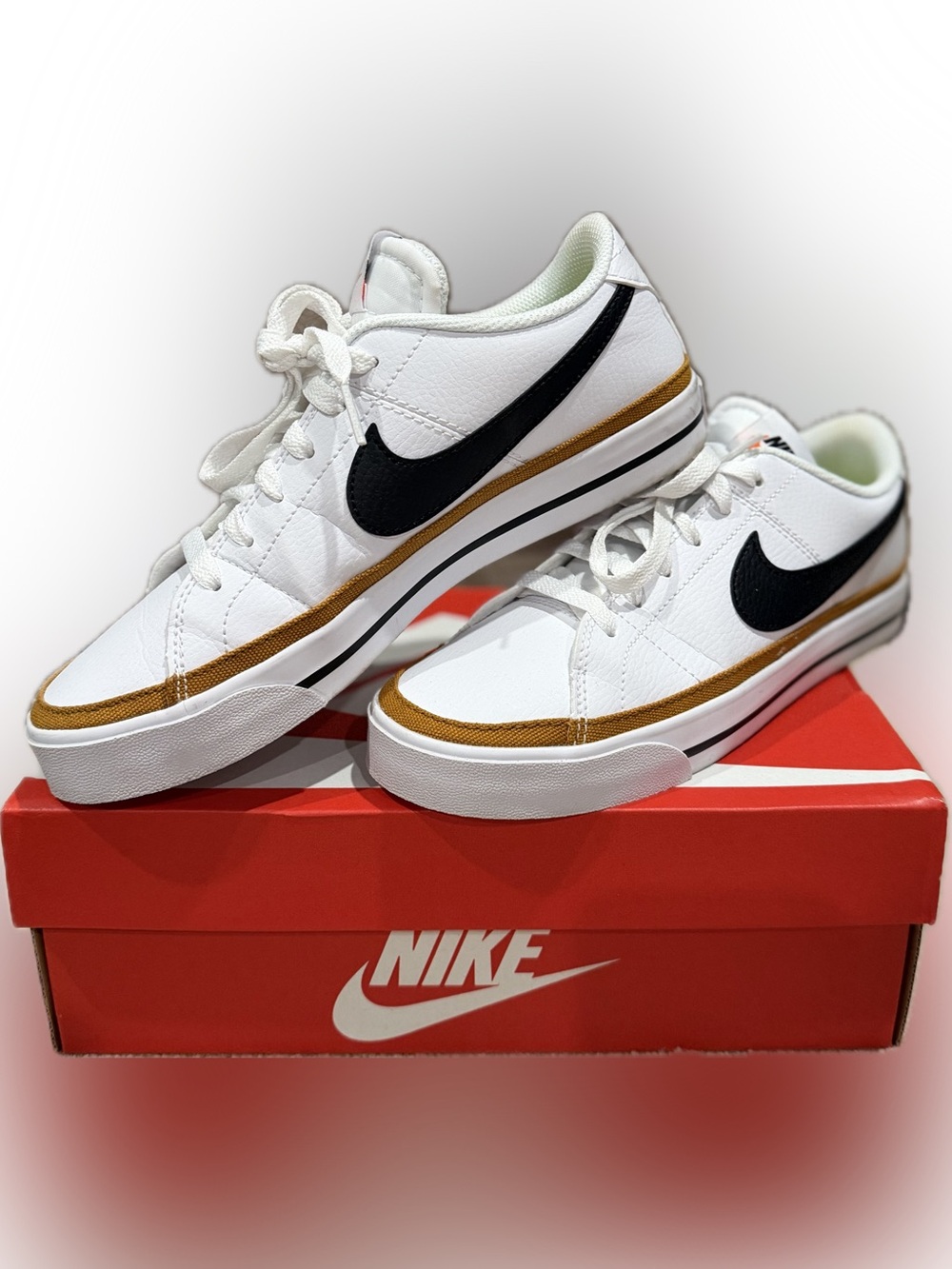 Nike White Sneakers with Black Swoosh and Gold Accent
